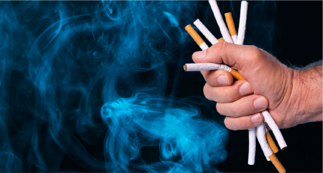 Mão segurando cigarros em arte sobre tabaco, dependência e Dia Mundial sem Tabaco.