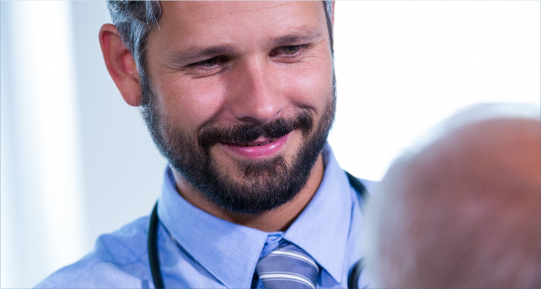 Médico conversando com paciente homem em ambiente de atendimento, com arte institucional do Hospital Átrios sobre a importância do cuidado com a saúde masculina.