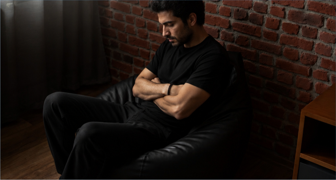 Homem sentado sozinho em ambiente interno, representando sofrimento emocional, ansiedade, depressão e a relação com uso abusivo de álcool ou drogas, em arte institucional do Hospital Átrios.