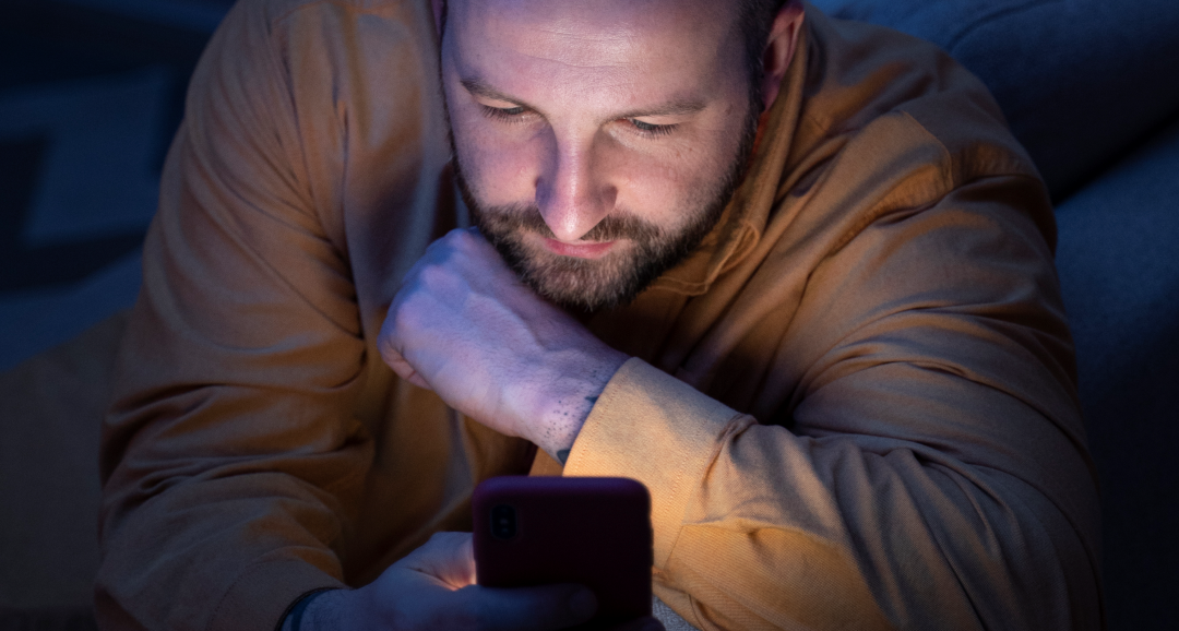 Homem utilizando o celular durante a noite, representando compulsão por apostas, perda de sono e dificuldade para parar