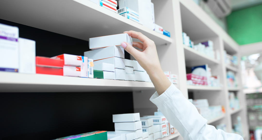 Pessoa retirando uma caixa de medicamento de uma prateleira, representando os riscos do uso sem acompanhamento profissional
